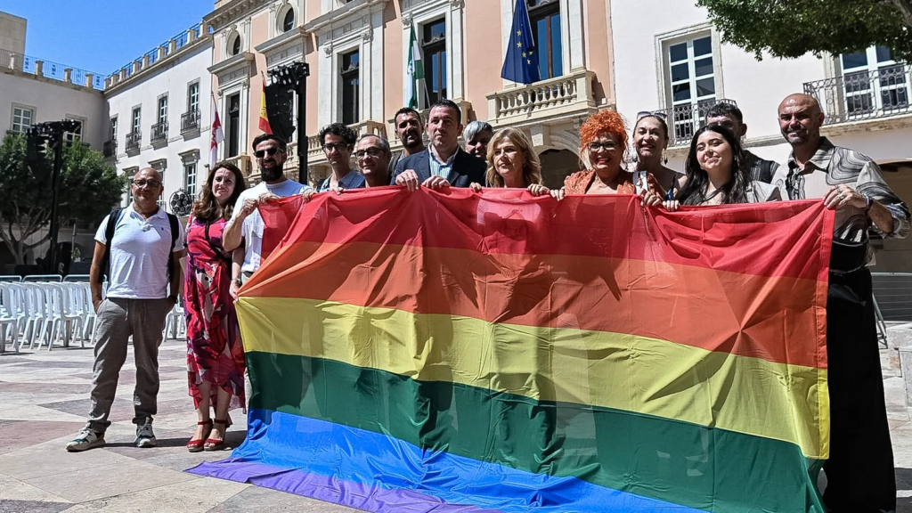 La concejal Paola Laynez con representantes colectivos LGTBI+ con la bandera arcoíris en la Plaza Vieja.